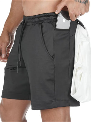 Black Tech-Knit cargo shorts with utility pockets, one holding a phone.