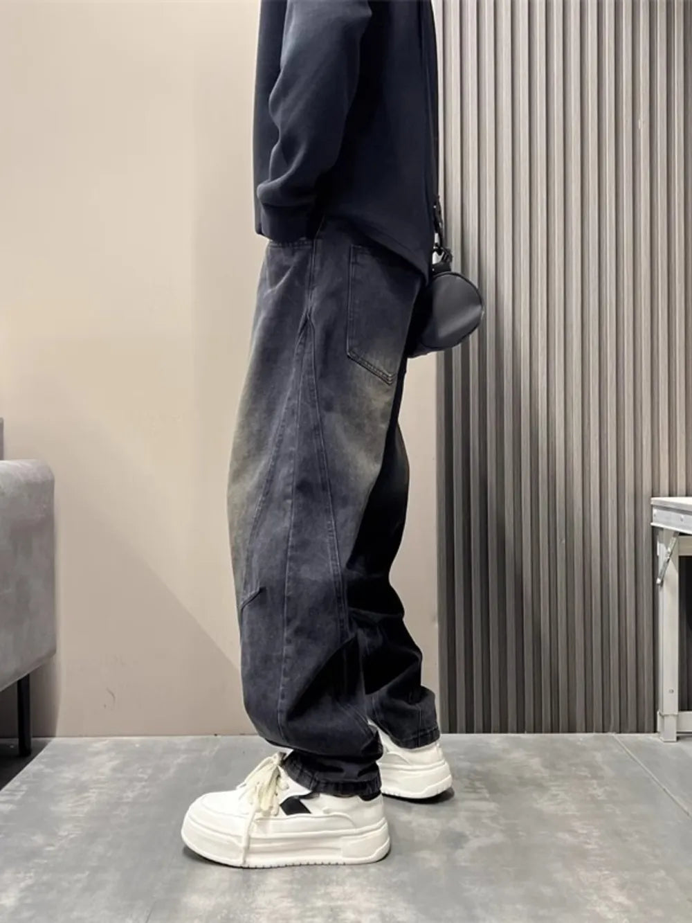 Oversized washed black men's jeans with tapered cuffs and a relaxed fit.