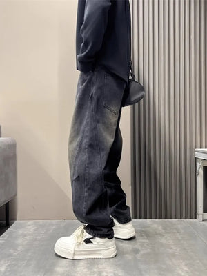 Oversized washed black men's jeans with tapered cuffs and a relaxed fit.