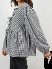 Black gingham tie-front peplum blouse with voluminous sleeves and tie details.