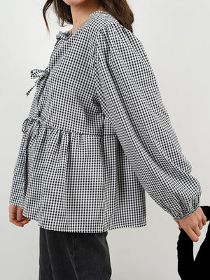 Black gingham tie-front peplum blouse with voluminous sleeves and tie details.