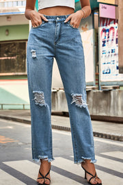 Distressed hem straight leg jeans in medium wash denim with ripped knees and frayed hems.
