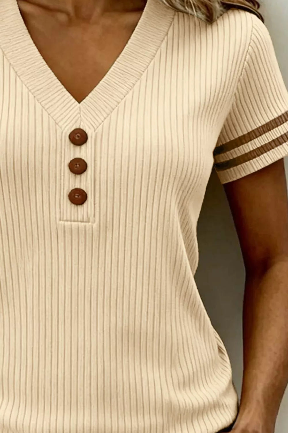Cream ribbed knit tunic top with V-neck and three brown button details.