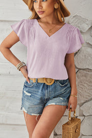 Lilac textured V-neck blouse with pleated flutter sleeves.