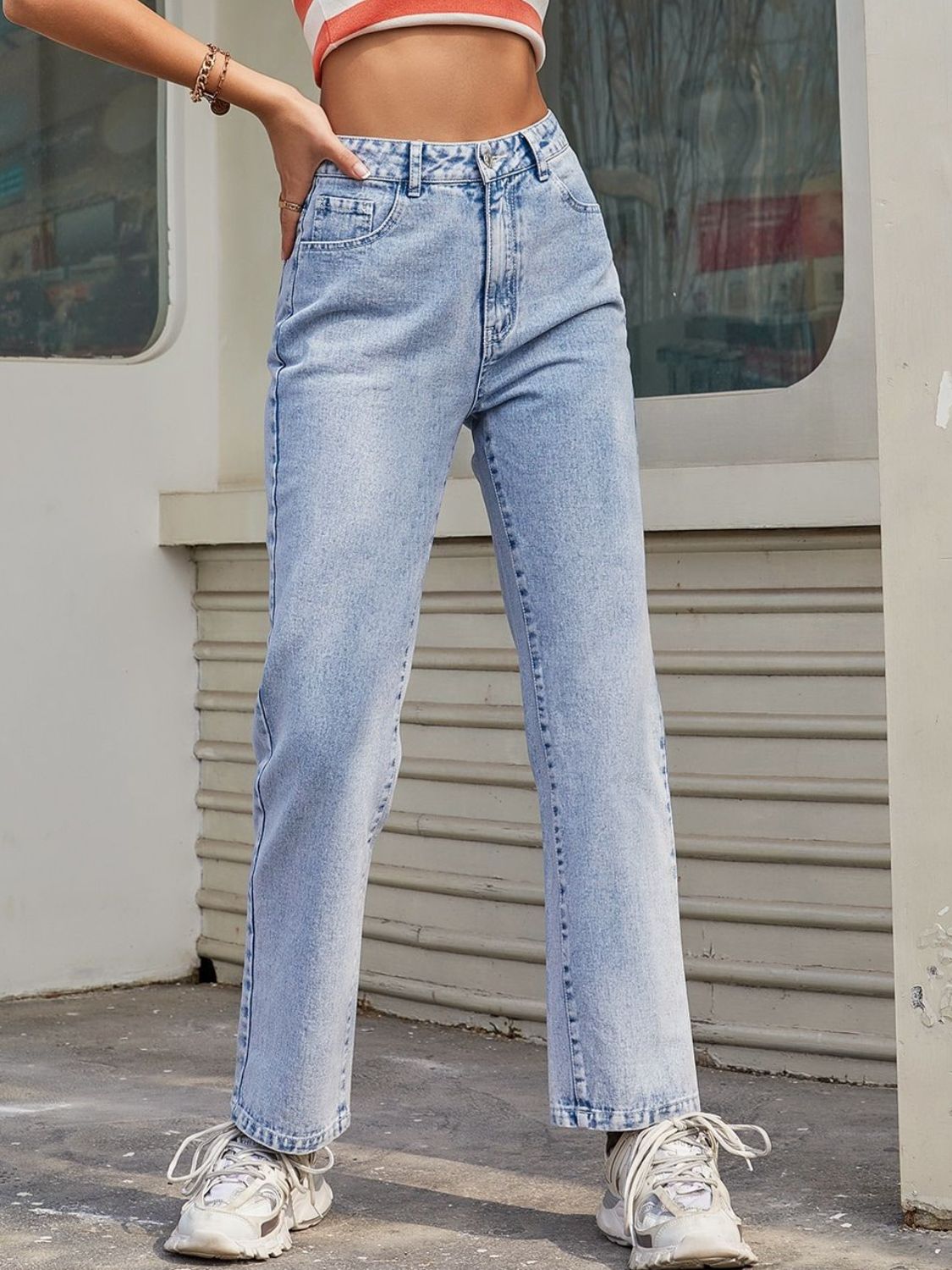 Light wash high-rise straight leg denim jeans made of cotton, buttoned front.