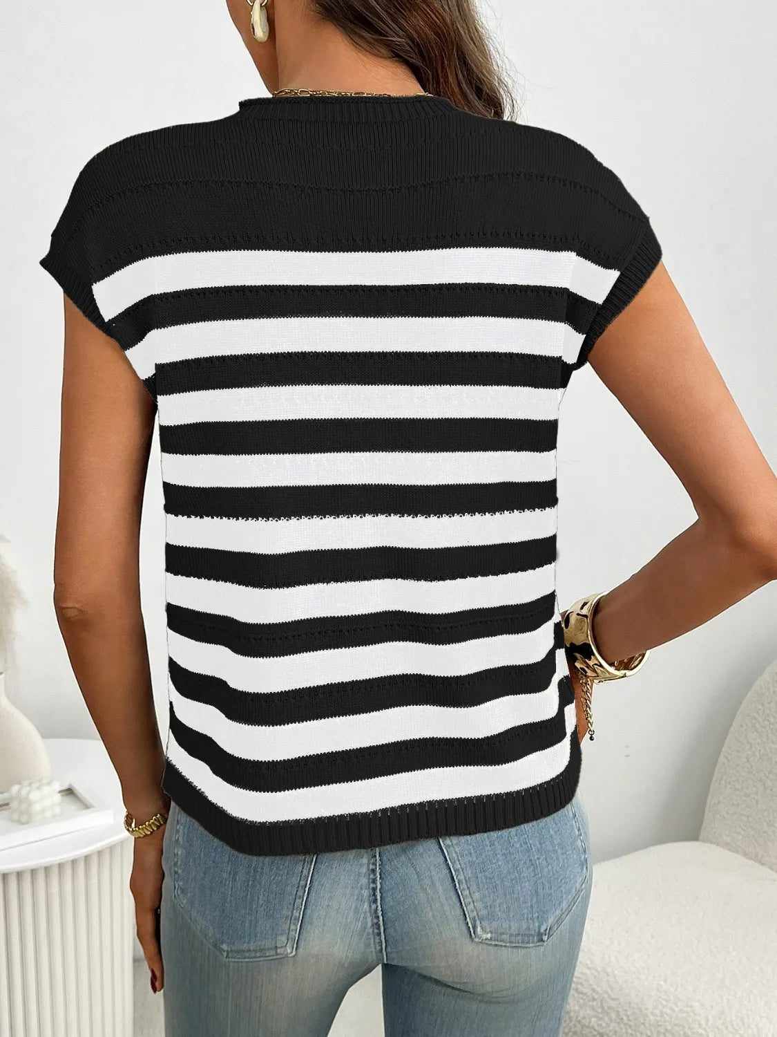 Black and white striped knit t-shirt with short sleeves and a pocket detail.