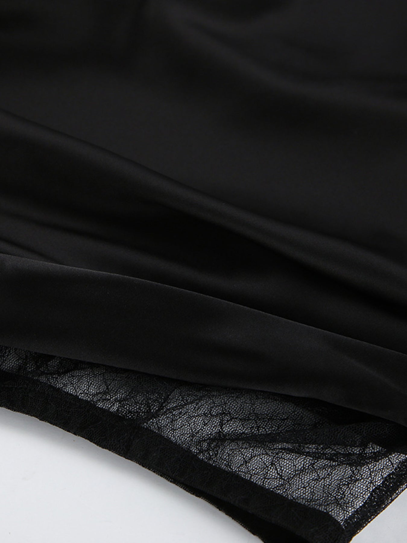 Black midi skirt with sheer lace panel detail and asymmetrical hem.