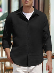 Men's black waffle knit button-up shirt with a classic collar, styled over a white tee.