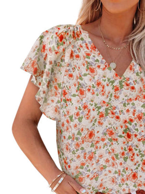 Floral flutter sleeve v-neck blouse in cream with orange and green floral print.