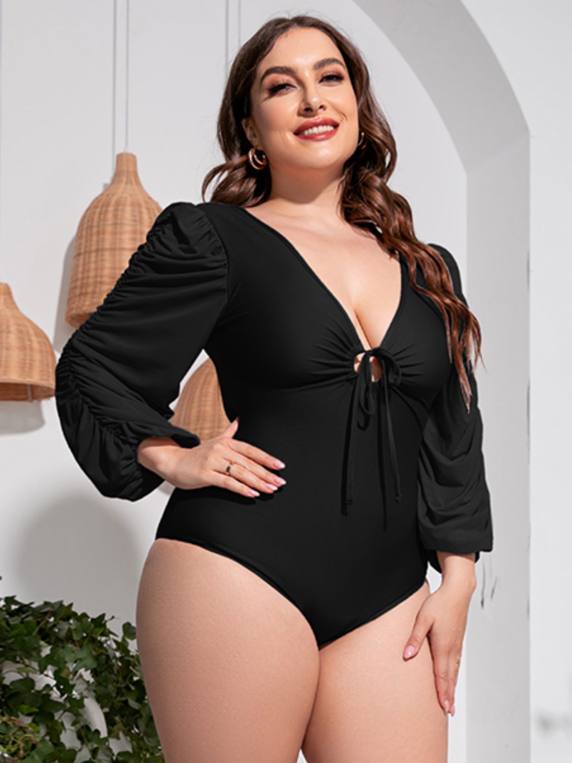 Black one-piece swimsuit with tie-front neckline and ruched balloon sleeves.