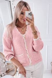 Blush pink bouclé cardigan with scalloped trim, gold buttons, and white pocket details.