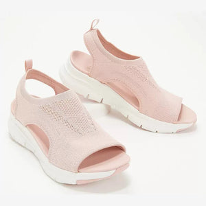 Pink breathable open-toe wedge sandals with chunky white soles and a knit upper.
