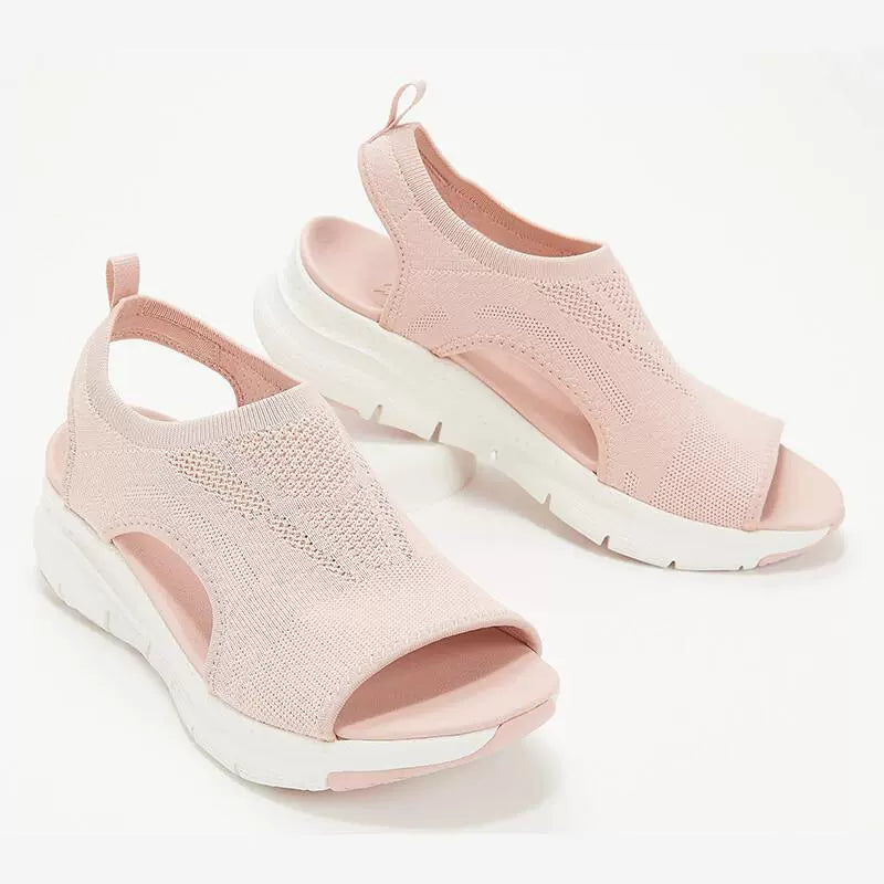 Pink breathable open-toe wedge sandals with chunky white soles and a knit upper.
