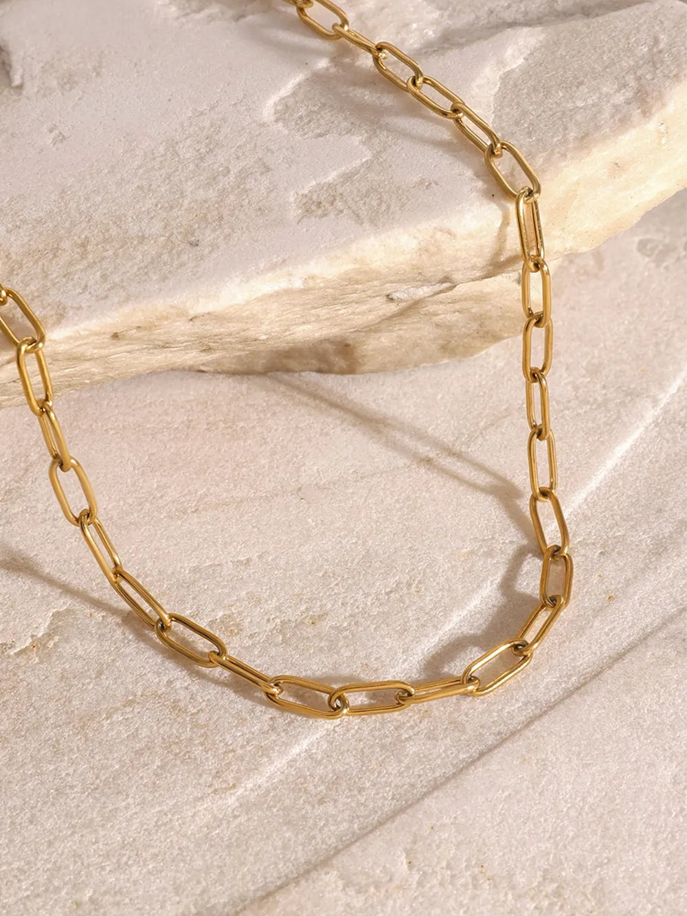 Gold celestial pendant layered chain necklace with delicate paperclip links.