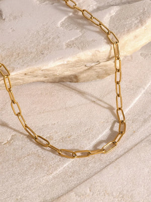 Gold celestial pendant layered chain necklace with delicate paperclip links.