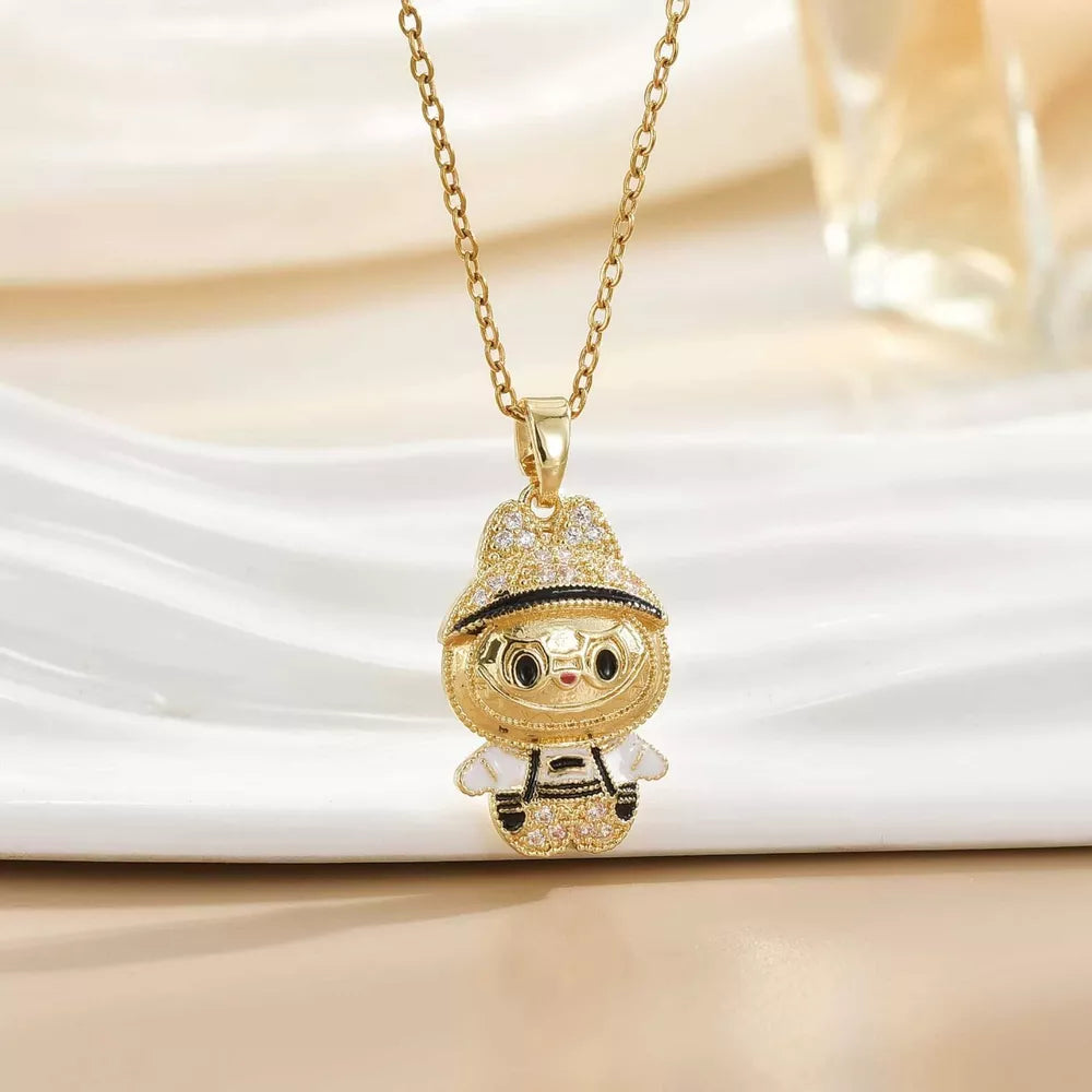 Gold-plated character pendant necklace with a whimsical design, featuring a jeweled hat and outfit.