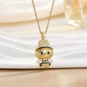 Gold-plated character pendant necklace with a whimsical design, featuring a jeweled hat and outfit.