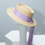 Classic straw boater hat with light purple ribbon and bow detail.