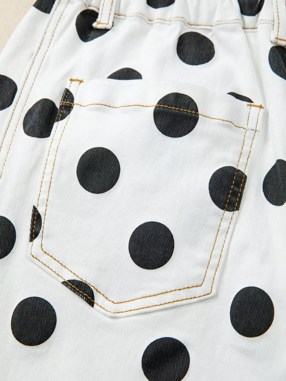 White denim jeans with black polka dots and a back pocket detail.