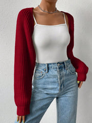 Burgundy acrylic knit bolero shrug with long sleeves and ribbed texture, worn over a white camisole.