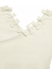 Ribbed knit V-neck t-shirt in cream with decorative bow details along the neckline.