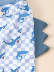 Baby blue checkered shorts with blue shark print and dinosaur tail detail.