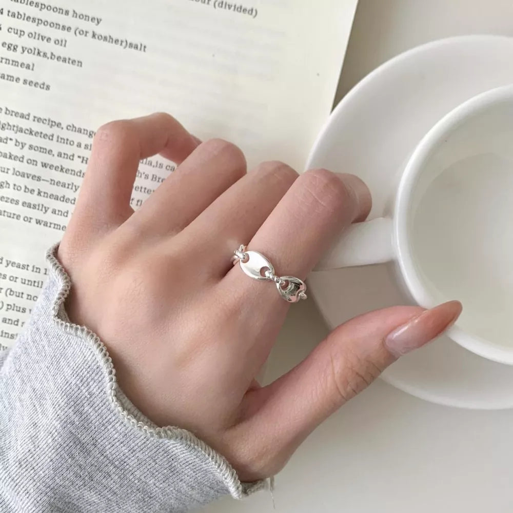 Interconnected oval link sterling silver ring with delicate chain detail.