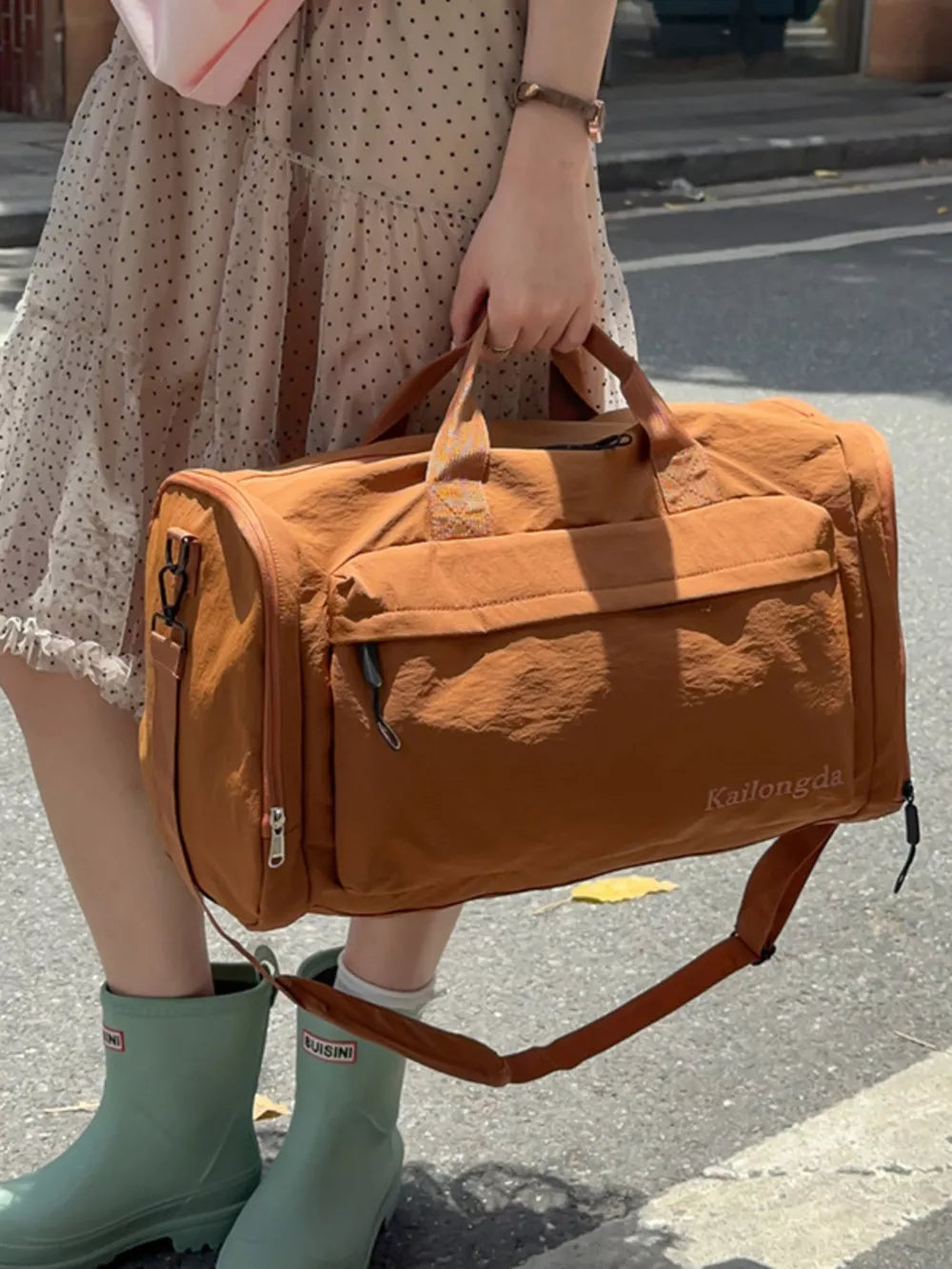 Luxurious Oxford cloth travel bag in caramel brown with detachable strap and exterior pockets.