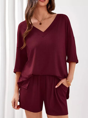 Burgundy V-neck two-piece loungewear set with cuffed sleeves and pocketed shorts.