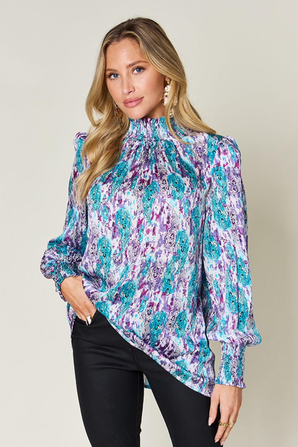 High neck abstract print blouse in red-violet and sky blue with smocked cuffs and collar.