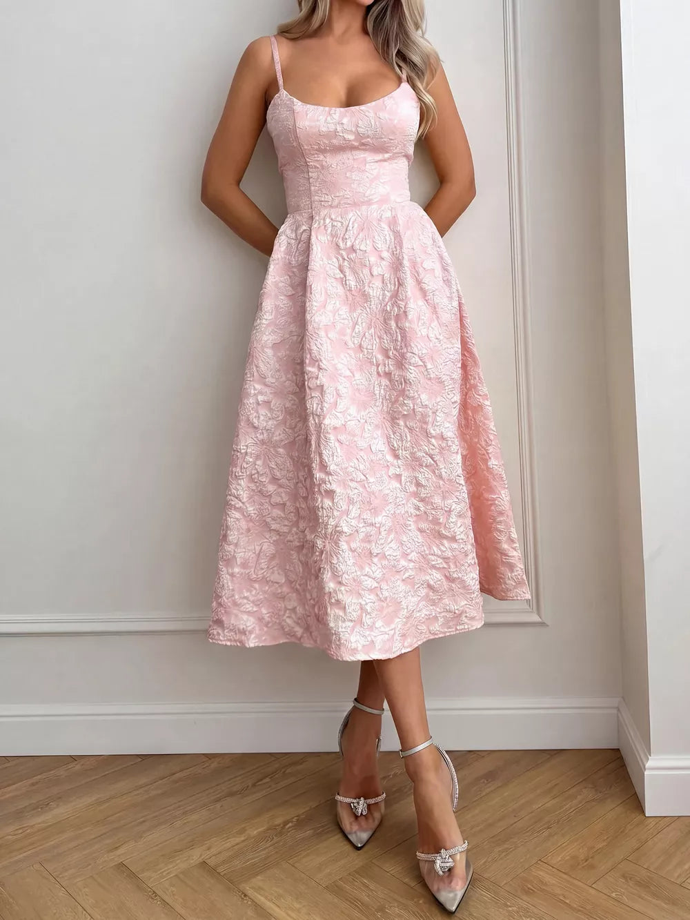 Blush pink A-line midi gown with textured floral pattern and spaghetti straps.