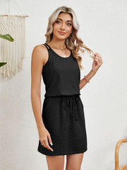 Black geometric eyelet crossover strap dress with drawstring waist and pockets