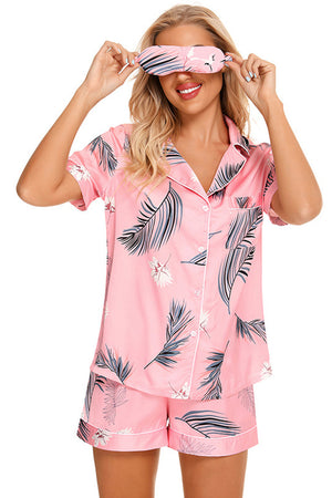Pink botanical print satin pajama set with button-down top and shorts.