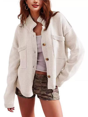 Ivory knit cardigan with button front, pockets, and ribbed collar.