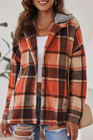 Plaid hooded shacket in orange, tan, and brown with button front and relaxed fit.