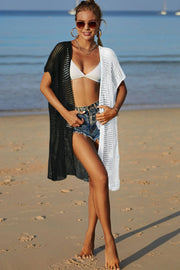 Colorblock crochet beach cover-up with short sleeves and open front, styled with denim shorts.