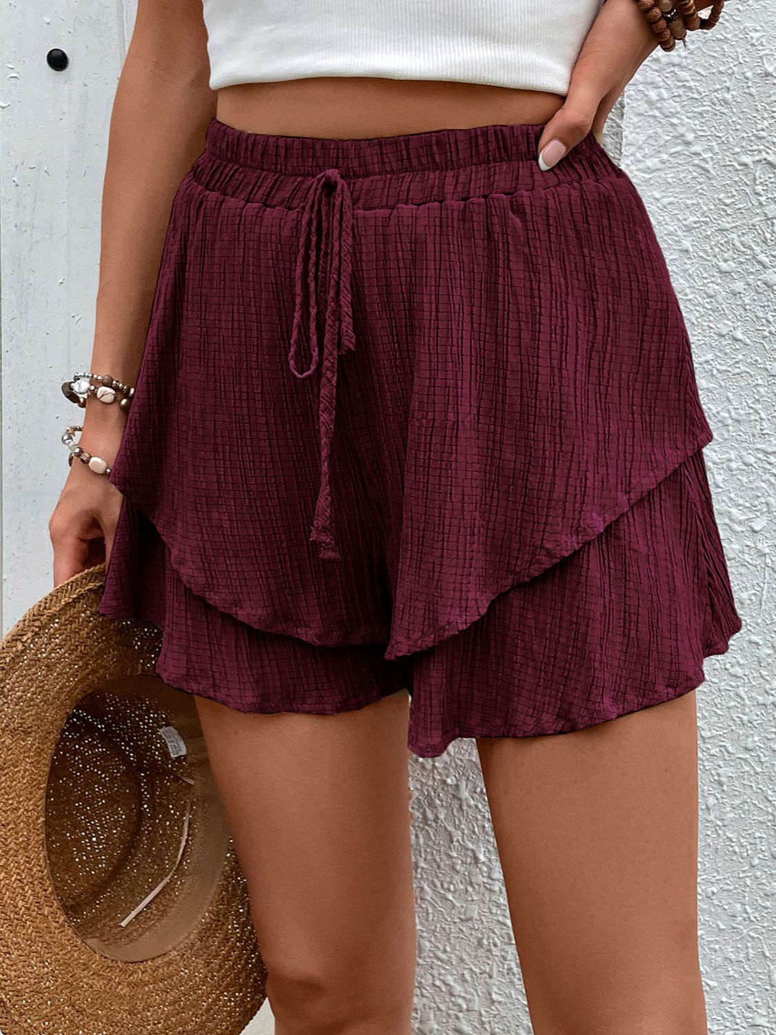Burgundy tiered gauze drawstring shorts with a textured pattern and ruffled hem.
