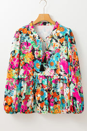 Floral print blouse with tie neck and tassel trim, tiered hem, long sleeves