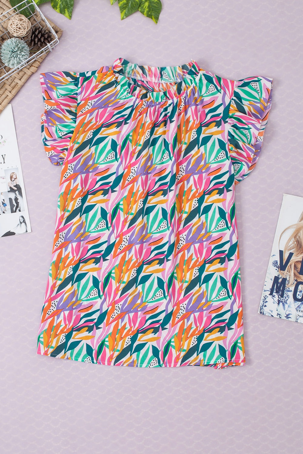 Multicolor leaf print blouse with ruffled collar and short flutter sleeves.