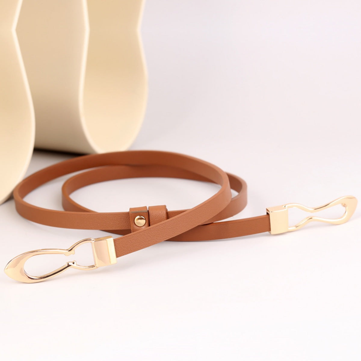 Caramel leather belt with interlocking gold buckle and adjustable strap