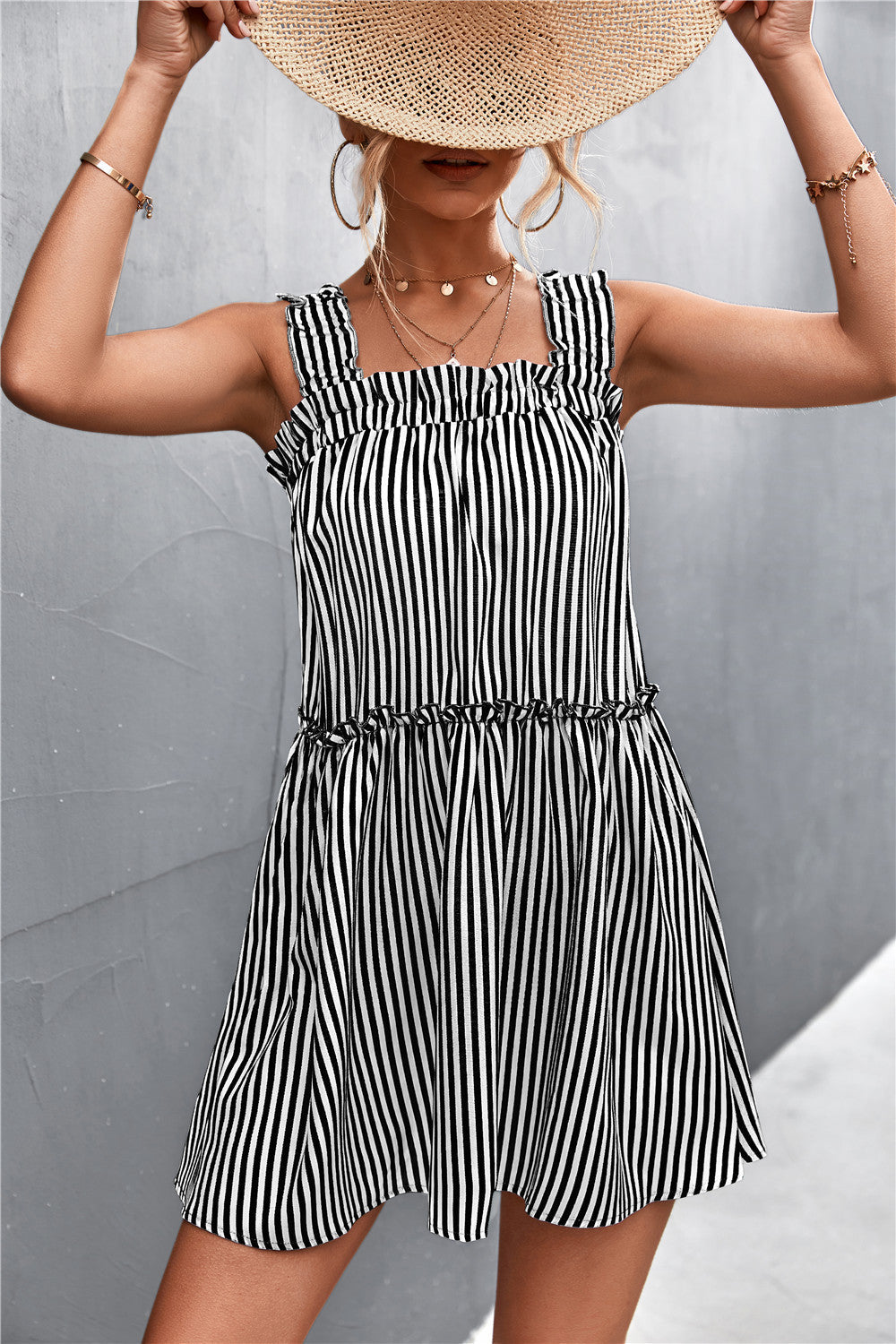 Black and white striped mini dress with ruffle yoke and hem, square neckline, and tie straps.