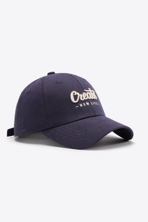 Navy baseball cap with embroidered "Create New Life" text and adjustable strap.
