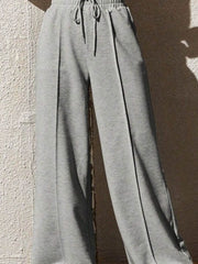 Gray sweatpants with drawstring and wide legs, featuring a relaxed fit and front seam detail.