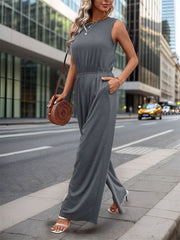 Sleeveless dark gray palazzo jumpsuit with gathered waist and pockets.