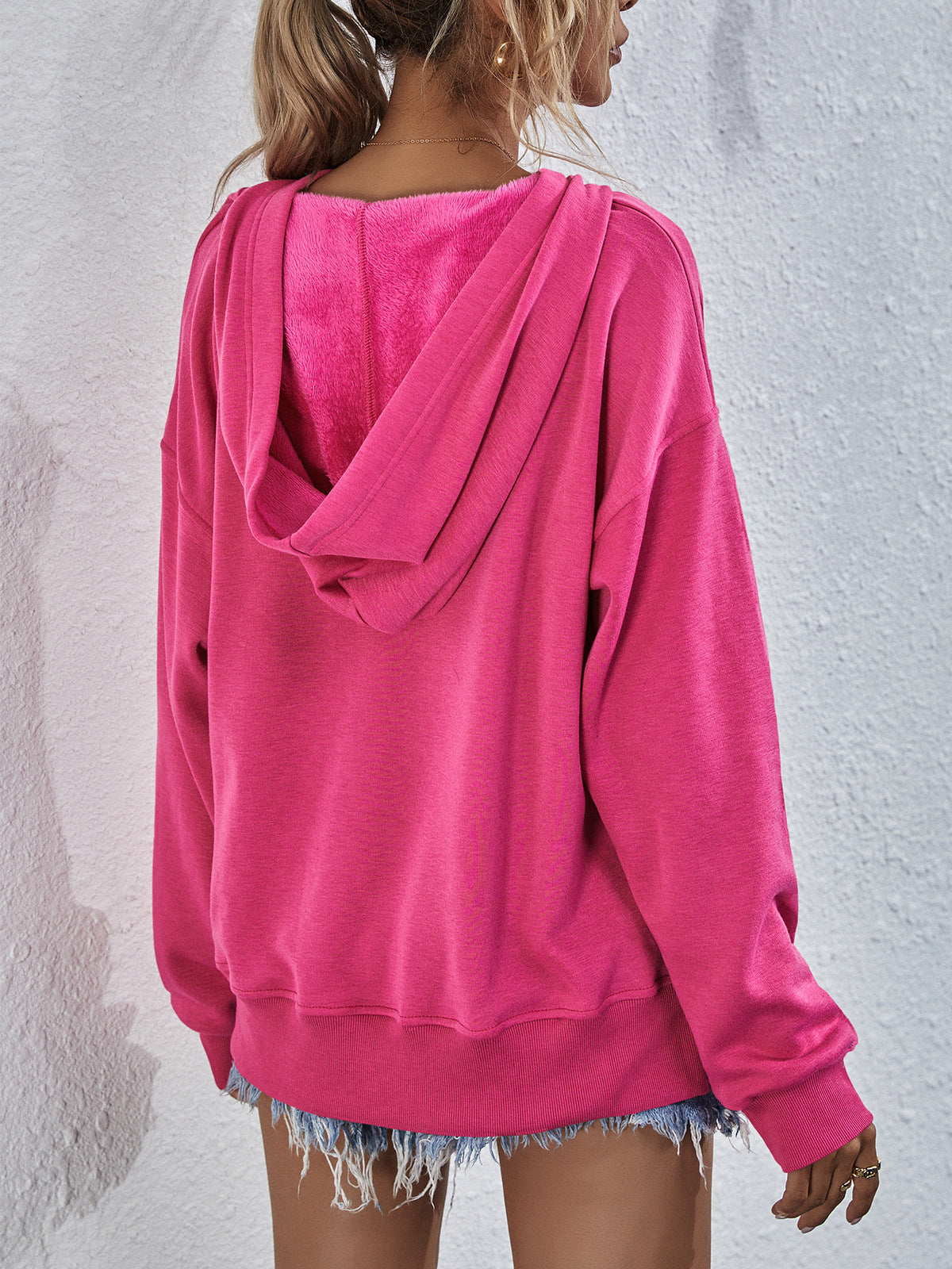 Boxy hot pink hooded sweatshirt with plush lining and split hem detail.