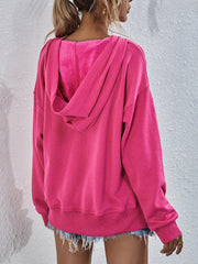 Boxy hot pink hooded sweatshirt with plush lining and split hem detail.