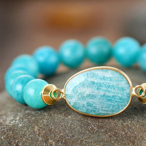 Aqua bead bracelet with gold bezel set oval stone and gold accents