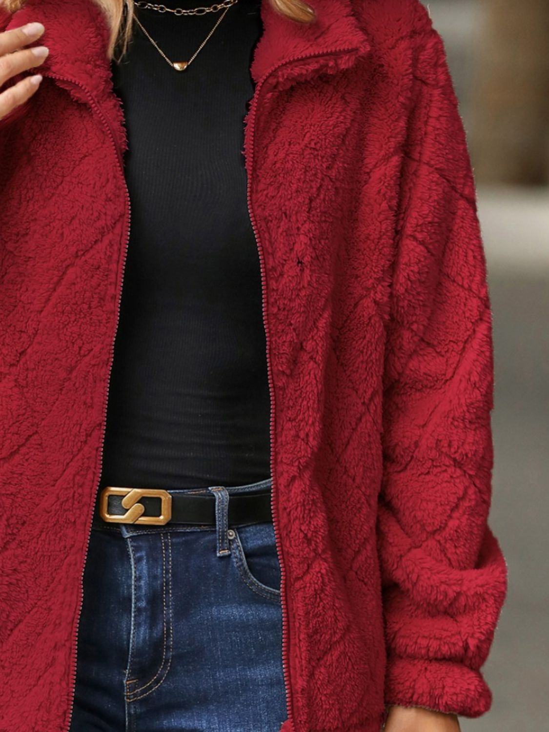 Deep Red textured teddy zip-up jacket with a diamond pattern, styled with a black top and jeans.