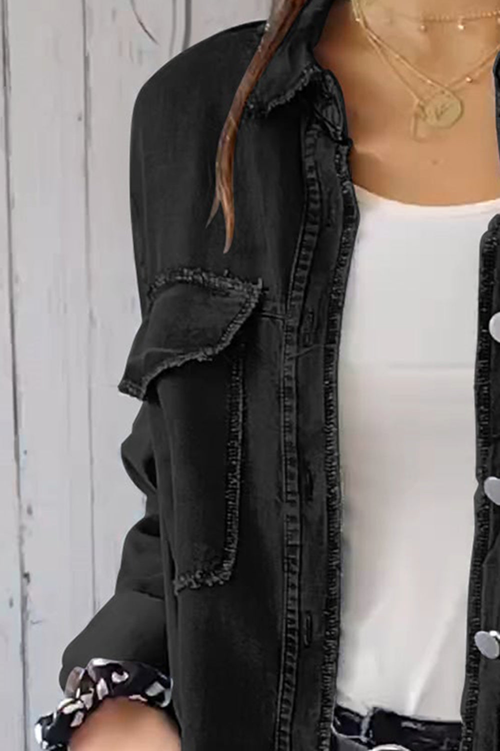 Black oversized denim shirt jacket with frayed pocket details and button front.