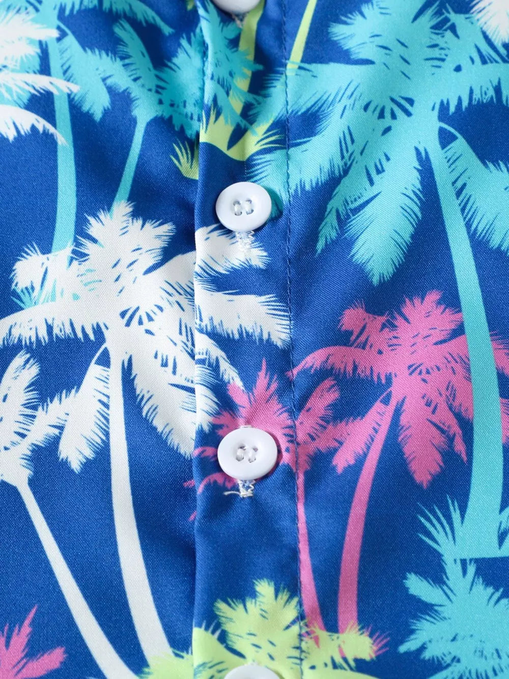 Baby shirt with multicolor palm trees, white buttons, and cotton fabric.